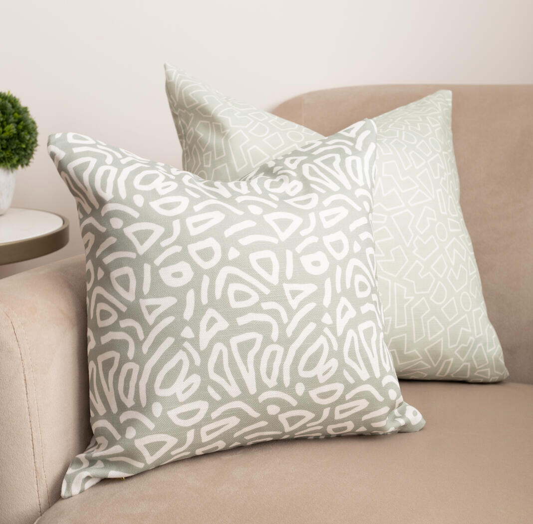 Scatter cushions with a minimal abstract design, in muted sage green.